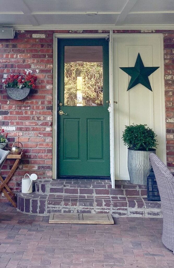 Red brick covered porch with green back door