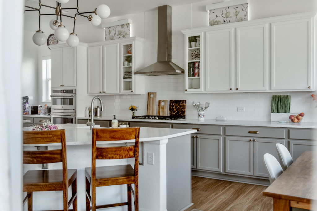 不锈钢厨房抽油烟机是一个永恒的设计元素在这个厨房白色和灰色