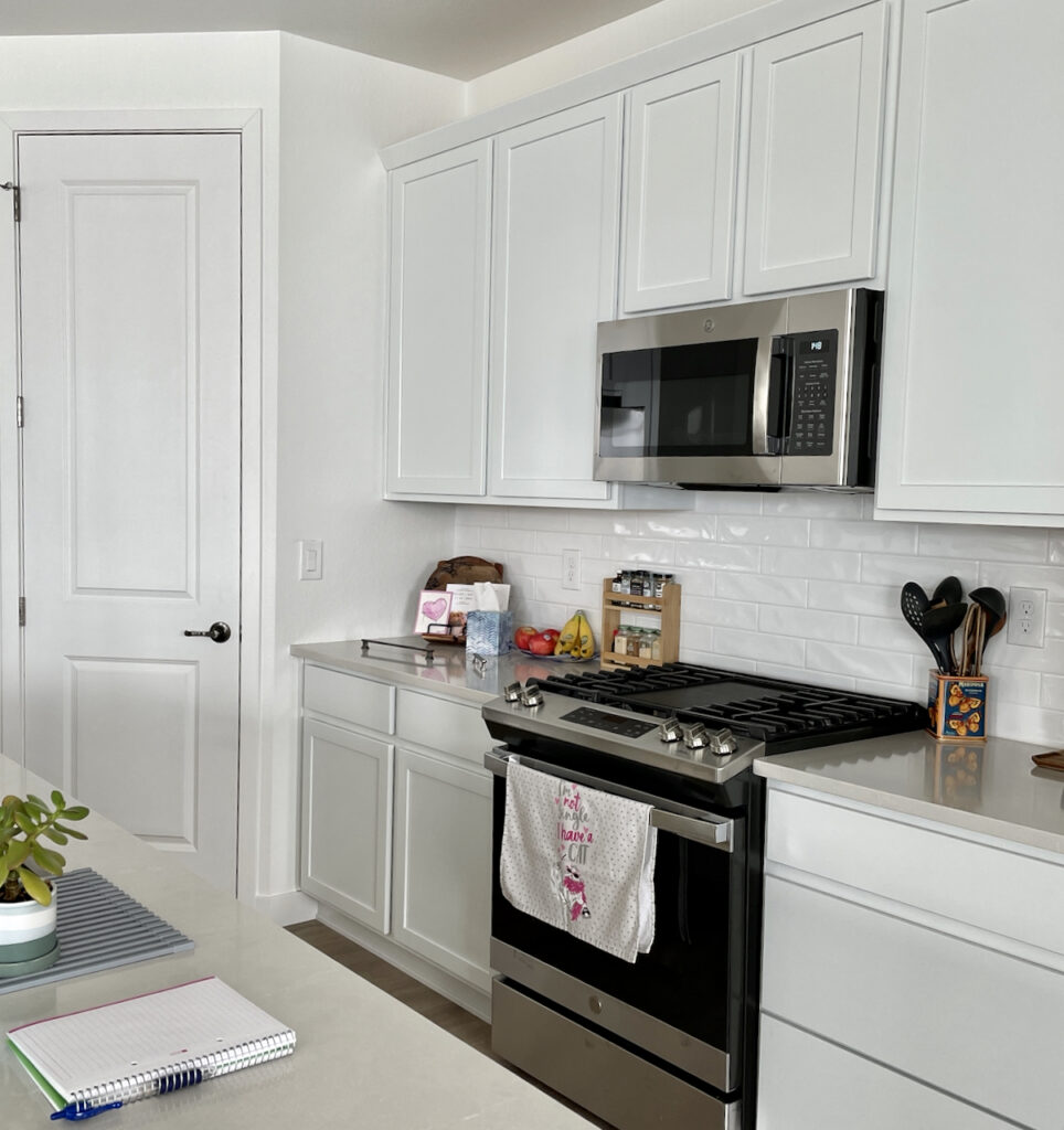厨房的墙壁和门都刷成了SW纯白色，橱柜是白色的，台面是灰色的。