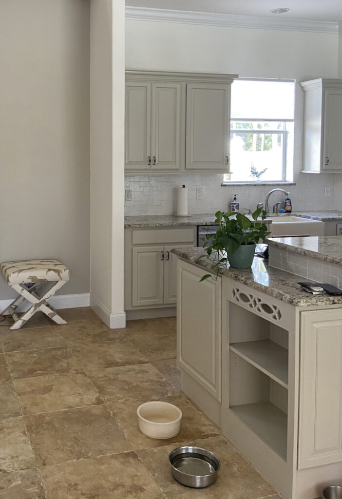 厨房里有Revere白镴橱柜、瓷砖地板和花岗岩台面。