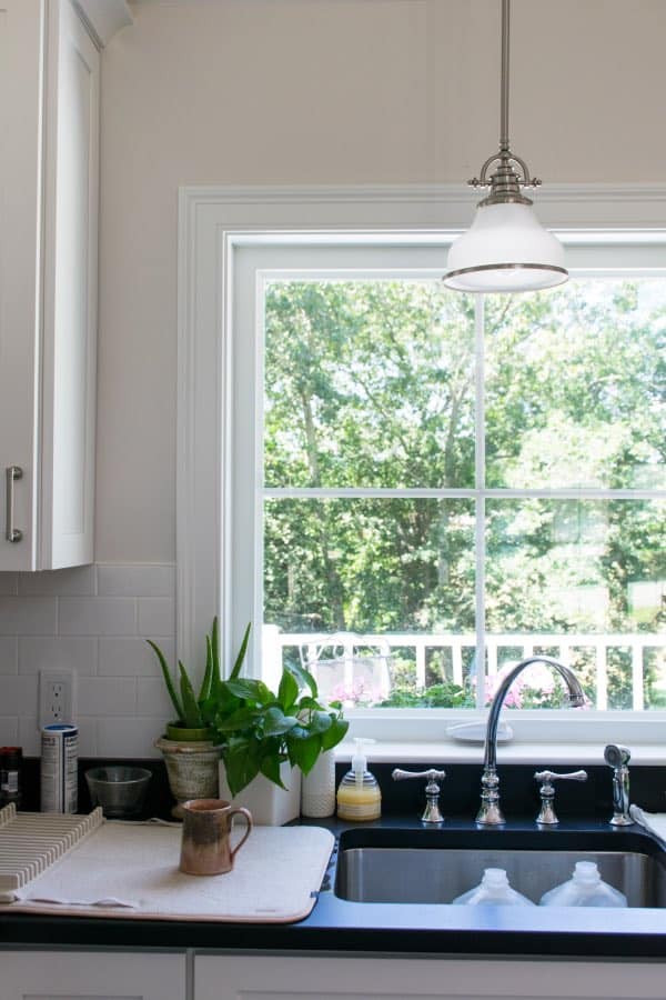 白色的厨房橱柜和厨房水槽用黑色计数器和广泛的厨房水龙头。