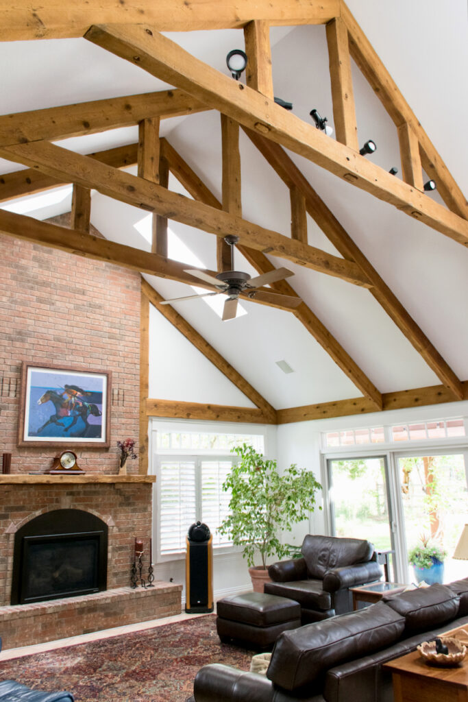 一间带木梁、高高的天花板和SW Extra White墙漆的家庭娱乐室